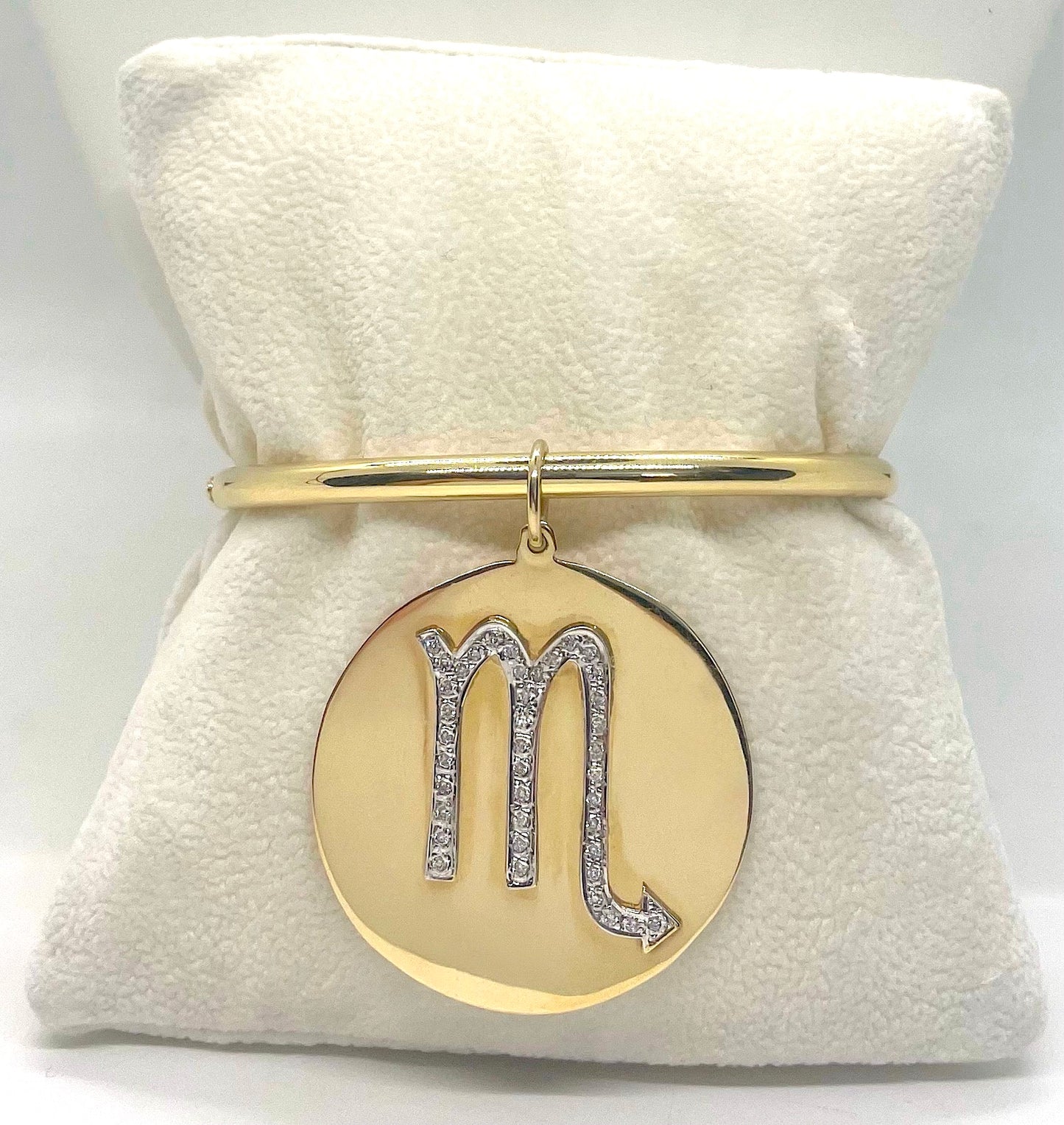 Gold bracelet with a 'Scorpio' symbol pendant on a white background.