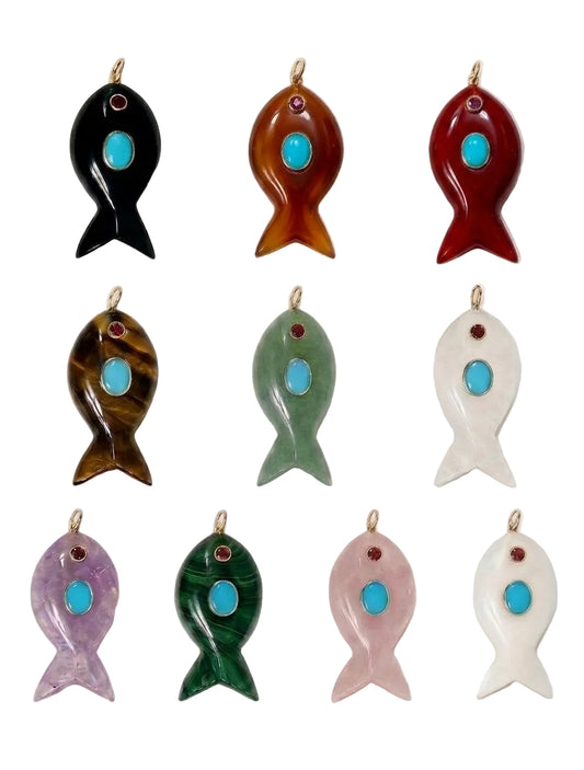 Nine fish-shaped jewelry pendants arranged in a 3-by-3 grid on a plain white background. Each pendant has a small gold loop at the top and a central turquoise-blue stone, with different body colors including black, amber-brown, red, mottled brown, light green, white, lavender, dark green, and pale pink.