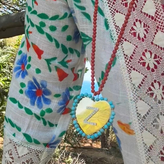Colorful fabric with floral patterns and a heart-shaped pendant with beads.