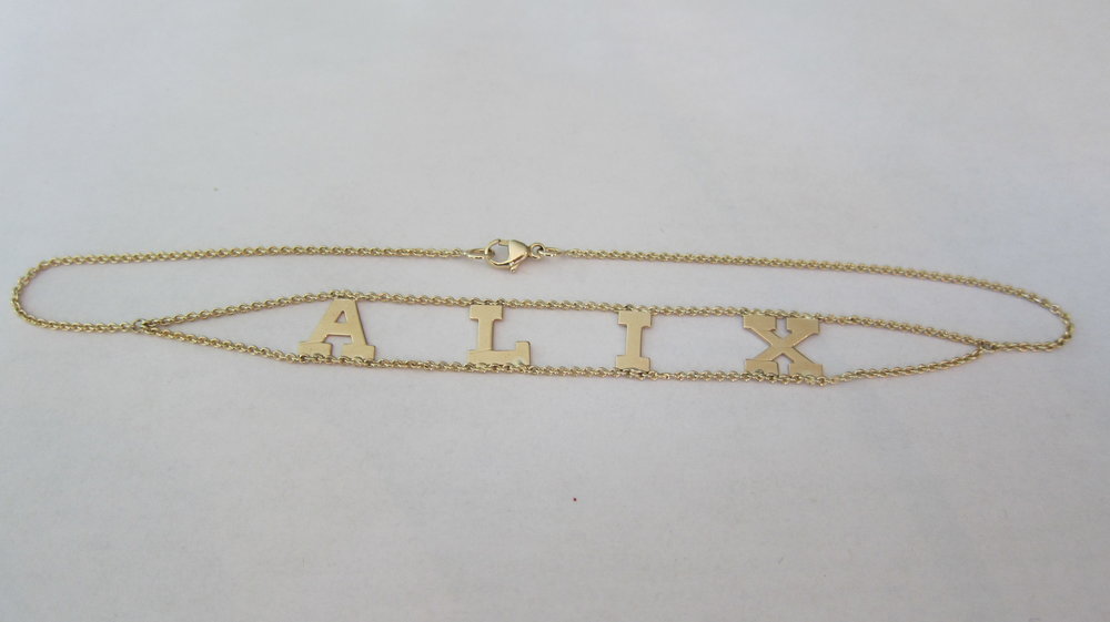 A 14k yellow gold 13 inch letter choker with the letter 'A' in the center, displayed against a white background.