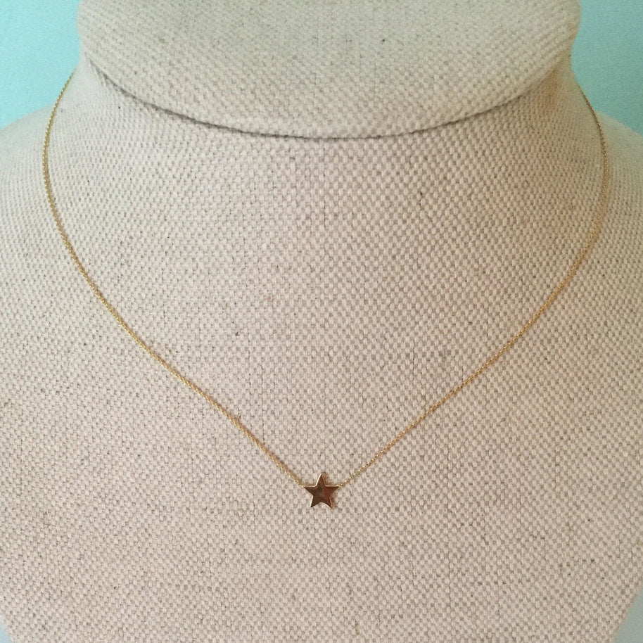 A 16 inch gold chain necklace with a 1/4 star-shaped pendant on a mannequin bust.