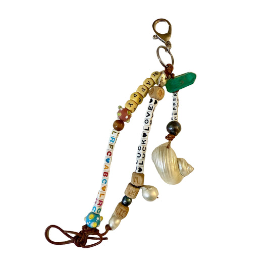 Colorful beaded keychain with various charms on a white background