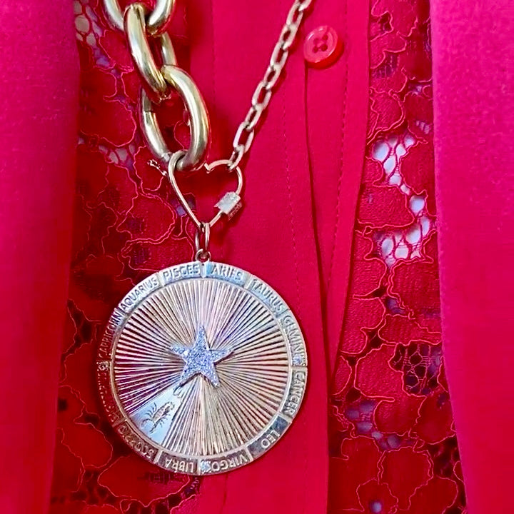 Gold chain with a star pendant on a red textured background