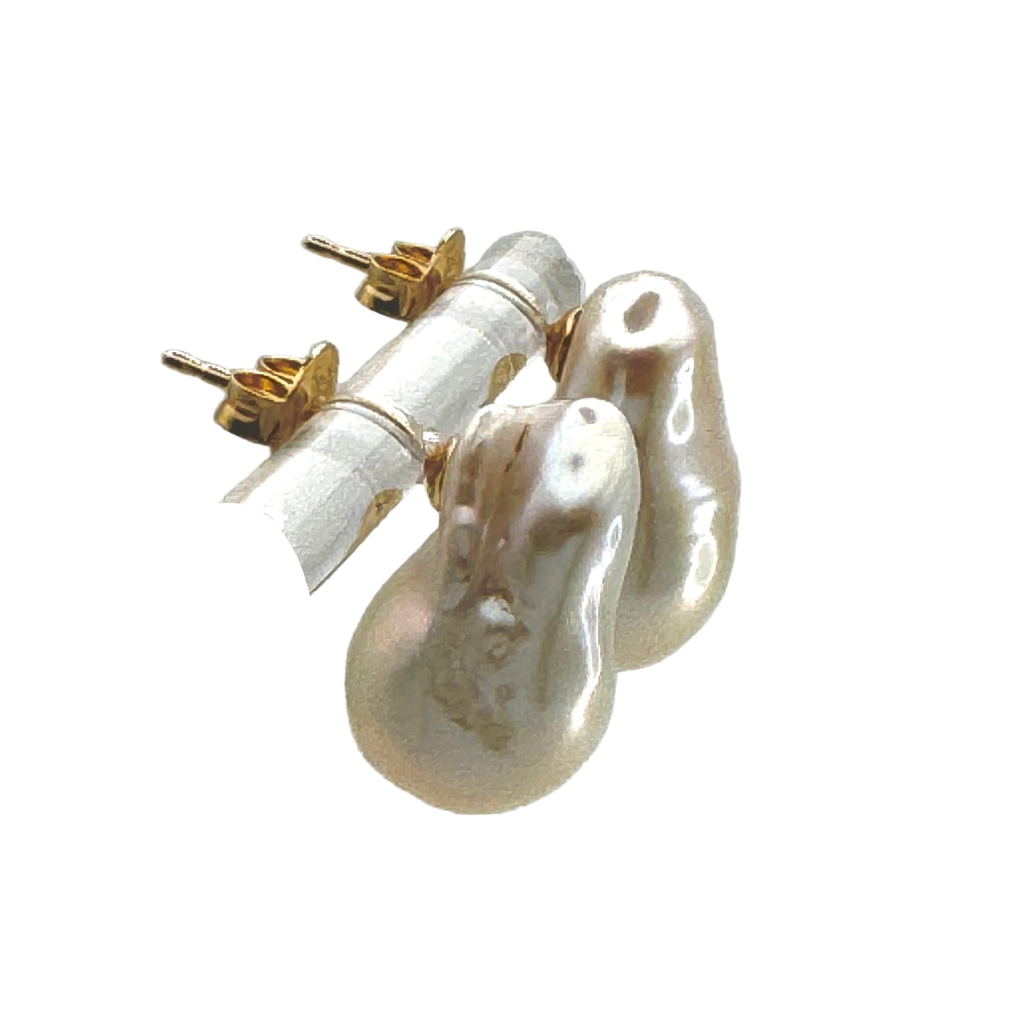 Pearl earrings on a clear stand against a light gray background