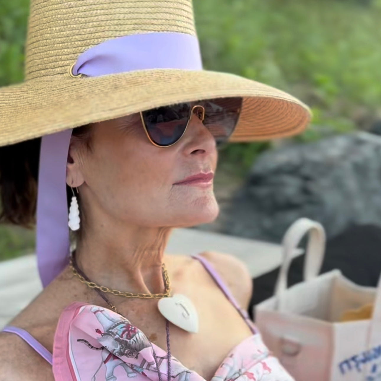 Woman wearing a wide-brimmed hat and sunglasses outdoors
