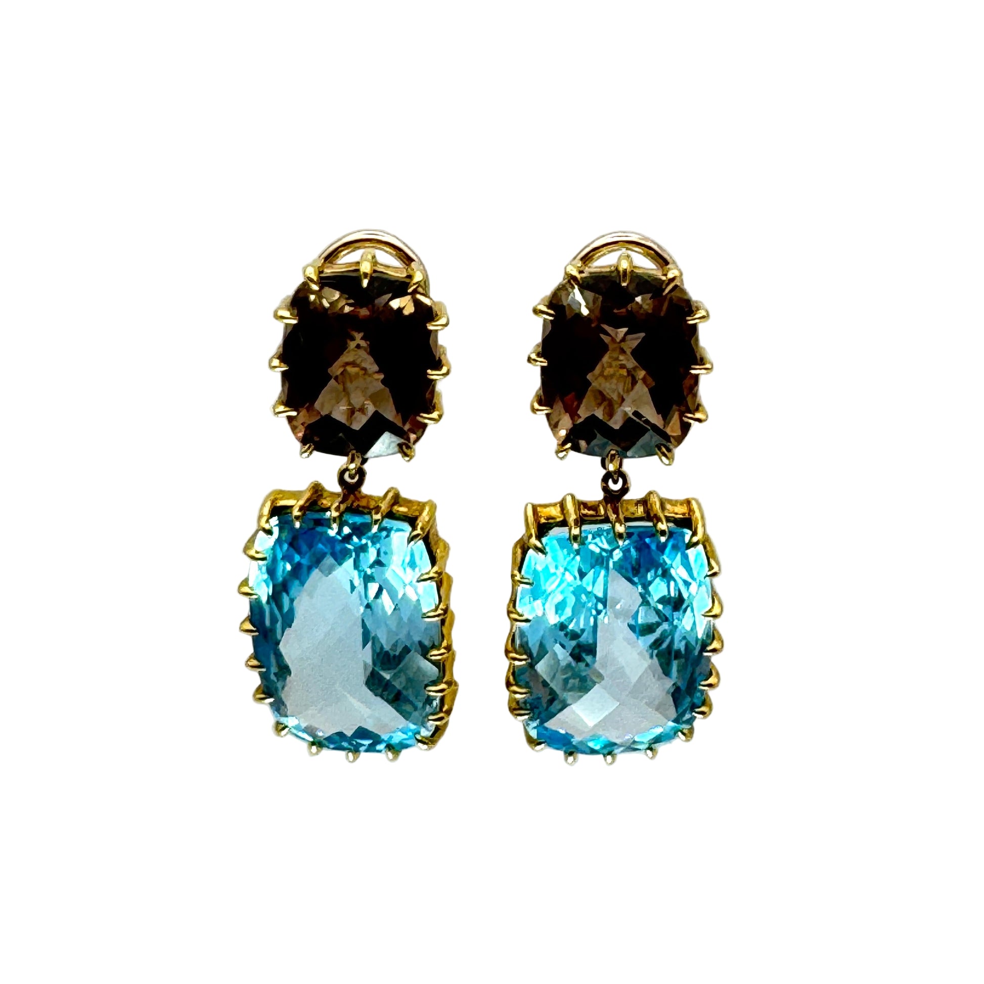 Pair of earrings with smoky topaz and blue topaz stones on a clear stand against a light gray background.