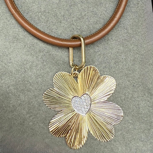 Gold clover-shaped pendant with a heart in the center on a brown leather strap.