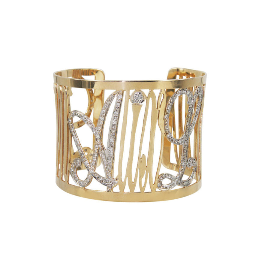 A 14k yellow gold cuff bracelet with pave diamonds, featuring a textured pattern with diamond encrusted surfaces.