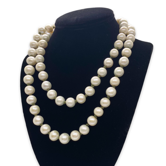 Two-layered pearl necklace on a black velvet stand against a white background