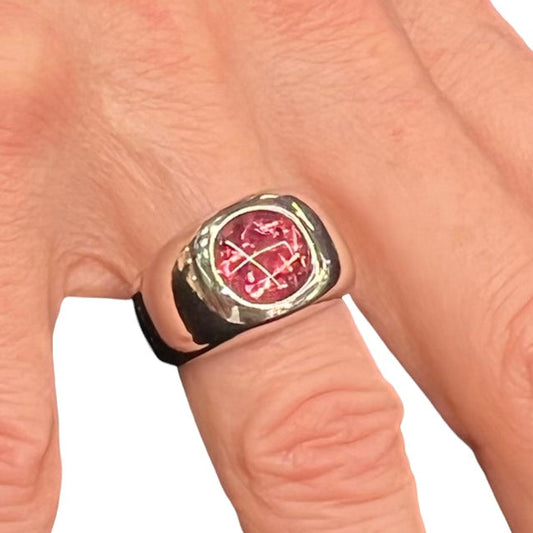 A hand wearing a pink tourmaline ring with 18K gold band.